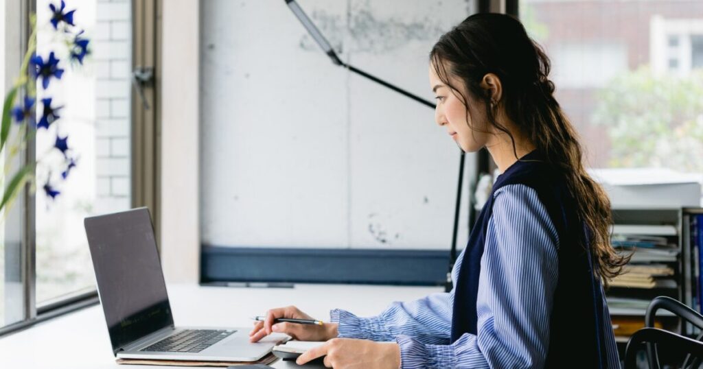 女性がノートパソコンに向かっている横がをの姿