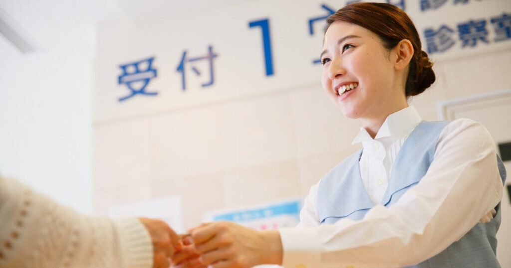 医療事務担当が患者様から保険証等を預かっている様子